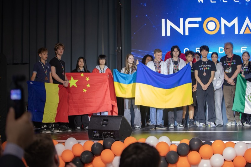 Students holding national flags on stage at Infomatrix